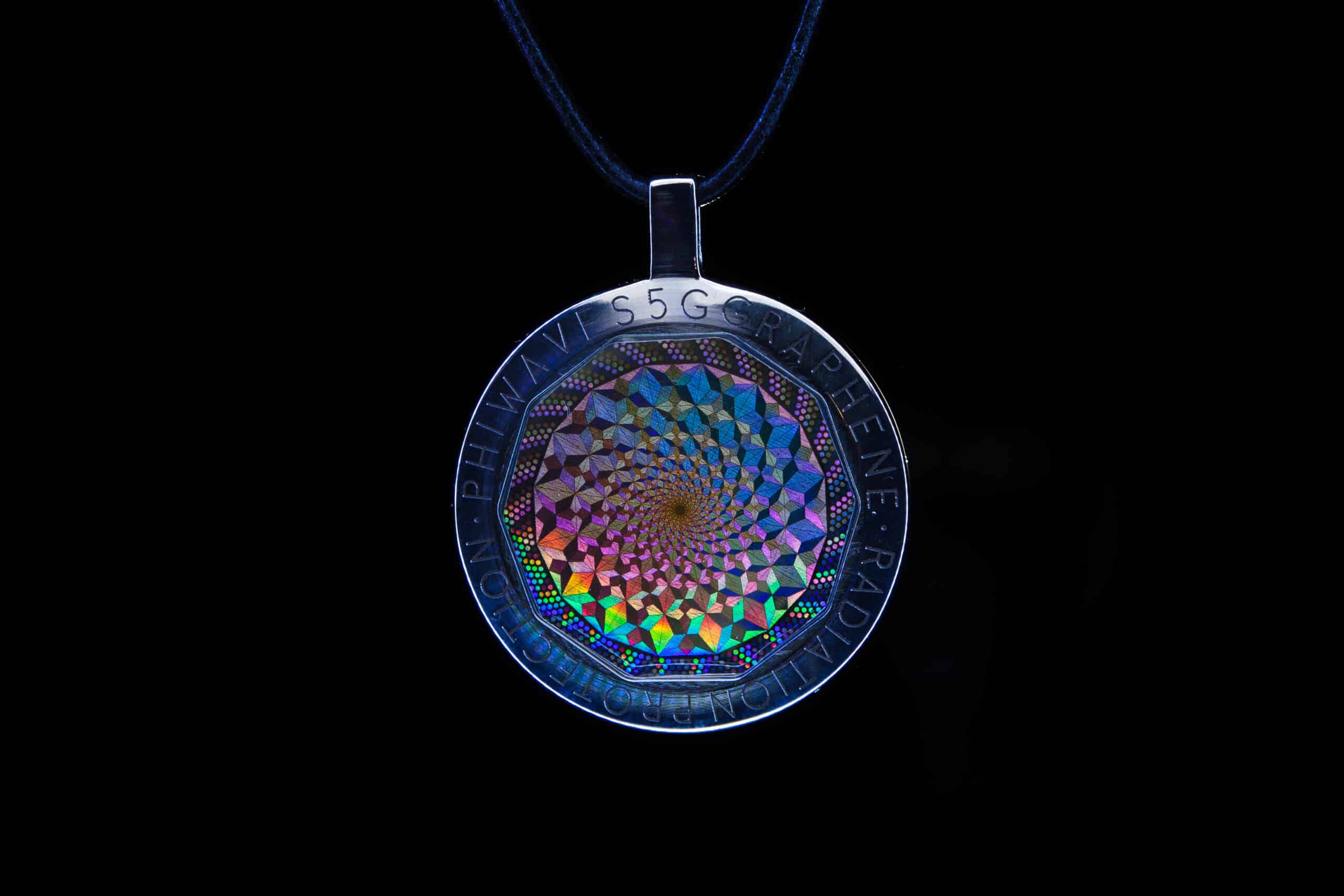 PhiWaves Jewel Diamond pendant featuring a colorful, spiraling design encapsulated in a shiny silver frame. The pendant is hung on a black cord, and its intricate pattern displays vivid holographic colors against a dark background.