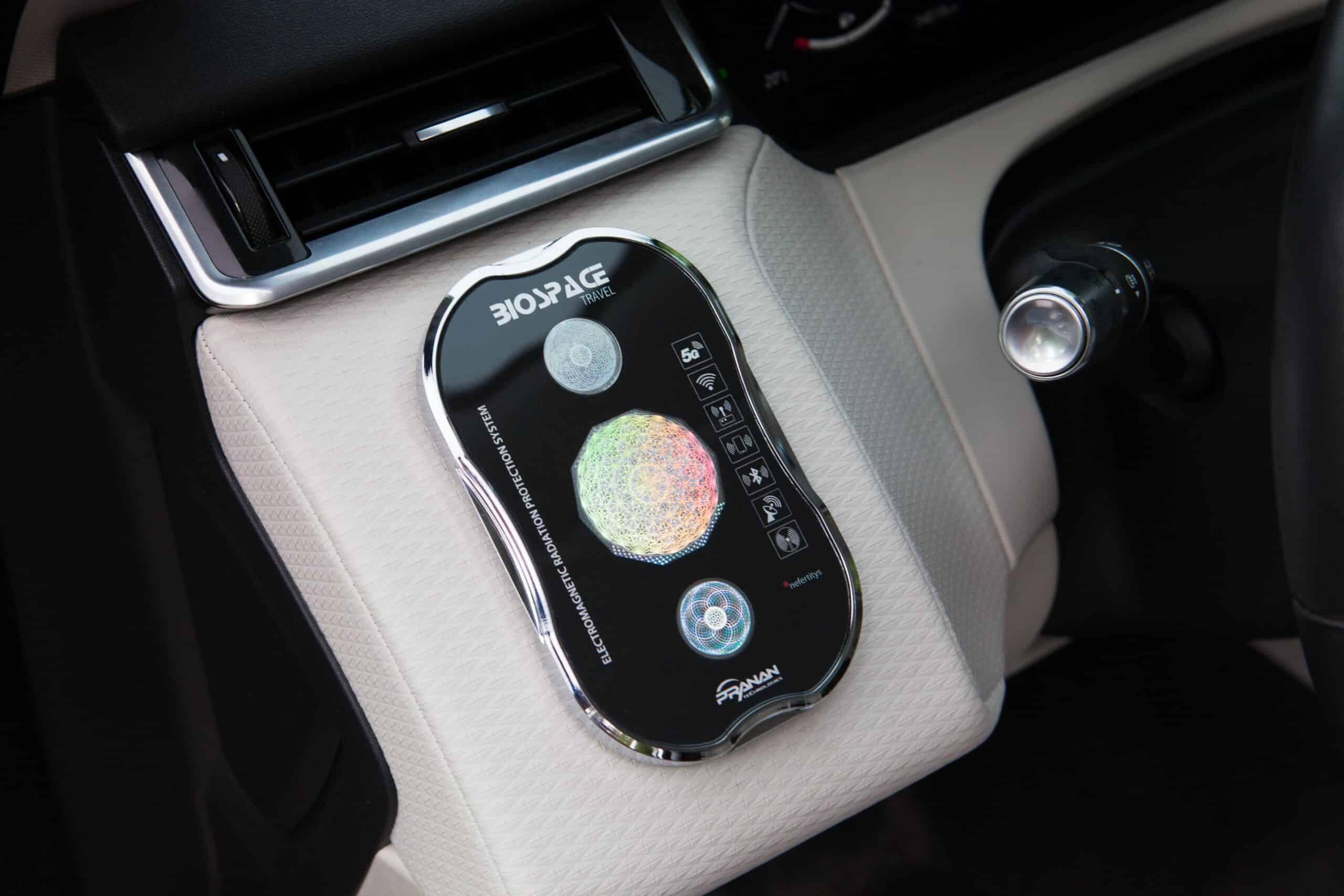 BioSpace Travel Diamond device with a sleek black exterior, shown on a light-colored car interior surface. The device features control buttons and a circular display, designed for travel purposes.