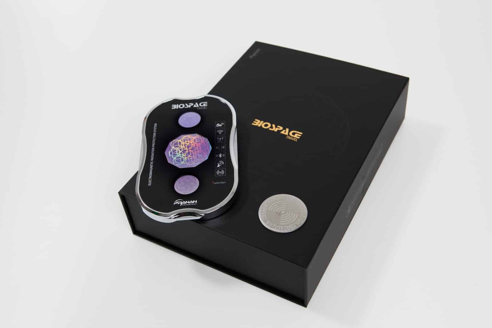 BioSpace Travel Diamond shown sitting on a black box. The device has a sleek, glossy design with a multicolored display and several control buttons. The packaging is minimalistic, displaying the BioSpace logo prominently in gold.