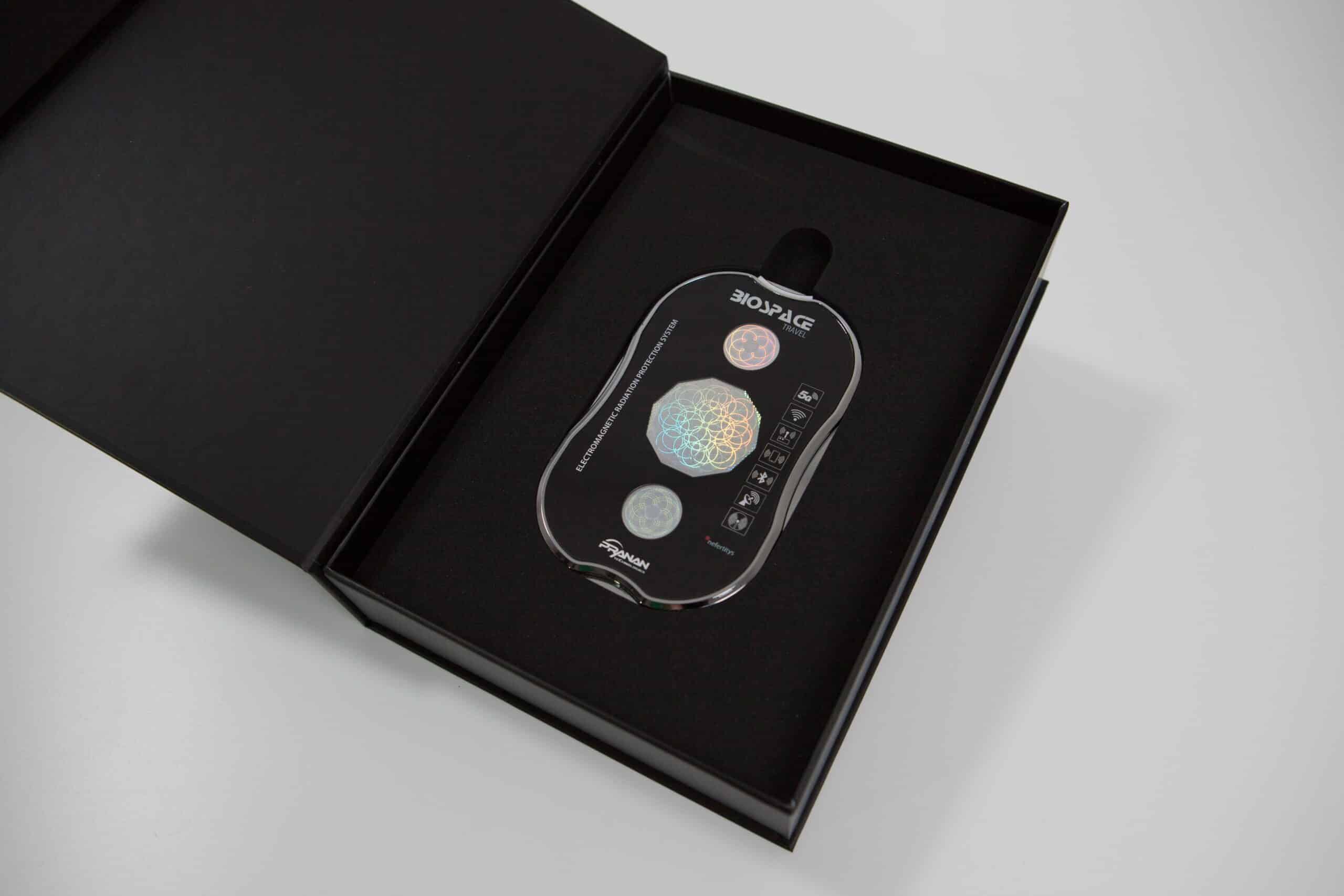 BioSpace Travel Diamond device, featuring a sleek black design with control buttons in a silver and pastel finish, housed in a black box. The diamond-patterned top adds a unique visual element.